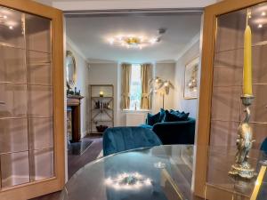 a living room with a glass table and blue chairs at Luxury Pitlochry Retreat- Cairngorms Ntl Park Gateway in Pitlochry