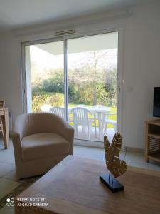 - un salon avec un canapé, une chaise et une fenêtre dans l'établissement Location appartement meublé bord de mer, à Fouesnant