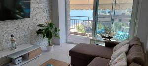 uma sala de estar com um sofá e uma varanda em Sea view Perea Apartment em Perea