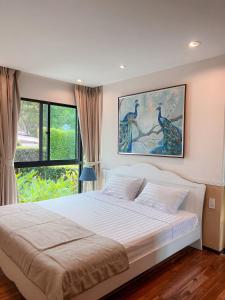 a bedroom with a bed and a large window at The Title Rawai: Beachfront condotel in Rawai Beach
