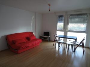 a living room with a red couch and a table at Apollon home Robertsau in Strasbourg