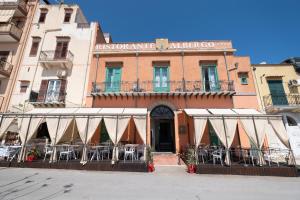 un edificio con mesas y sillas delante de él en Hotel Borgo di Ciàula, en Santa Flavia