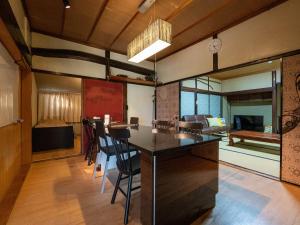 een eetkamer met een tafel en een woonkamer bij SUMITSUGU HOUSE Grandpa in Kumamoto