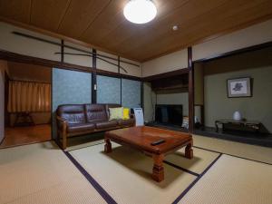 a living room with a couch and a coffee table at SUMITSUGU HOUSE Grandpa in Kumamoto