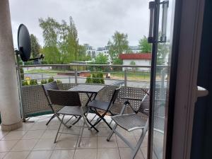 a table and chairs on a balcony with a view at 9 APARTAMENT VILLA NORD - parking in Jastrzębia Góra