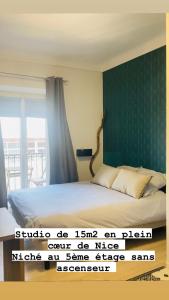 sypialnia z łóżkiem i zieloną ścianą w obiekcie Studio plein coeur de Nice 24 24H 7 7J w Nicei