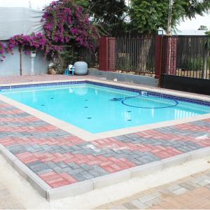 a large swimming pool with a brick floor and a brickkered sidx sidx at Platinum Hotel in Gaborone