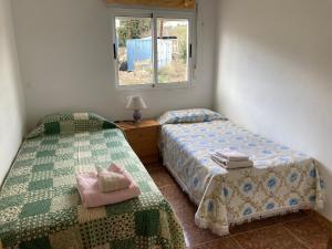 1 dormitorio con 2 camas y ventana en La casa de Paco el Ventero El Secadero, en Almócita
