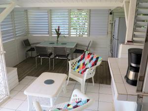 un pequeño porche con mesa y sillas en Bungalow Soleil, en Sainte-Anne