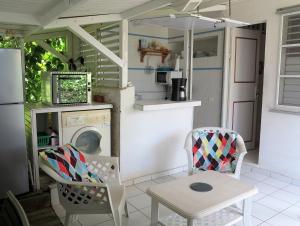 a kitchen with a washing machine and a table and chairs at Bungalow Soleil in Sainte-Anne