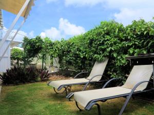 a group of chairs sitting in a yard at Bungalow Soleil in Sainte-Anne