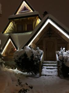 una casa cubierta de nieve con luces encendidas en Domek Krupówki z widokiem na Giewont, en Zakopane