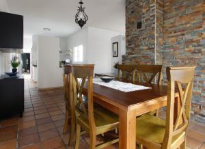 cocina y comedor con mesa de madera y sillas en VILLA ELLY, en Conil de la Frontera