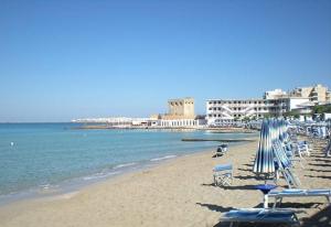plaża z leżakami i parasolami oraz ocean w obiekcie La Maison De Lulu w mieście Gallipoli