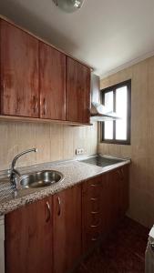 d'une cuisine avec des placards en bois, un évier et une fenêtre. dans l'établissement El Palaero, à La Alberca