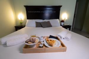 bandeja con dos platos de comida en una cama en Hotel Borgo di Ciàula, en Santa Flavia