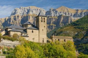 an old castle on a hill with mountains in the background at Apartamentos IRENE en el Pirineo Aragonés in Sabiñánigo