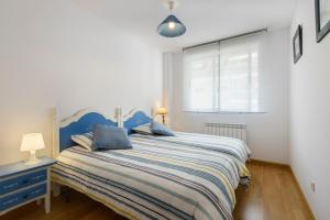 a bedroom with a large bed with a blue headboard at Apartamentos IRENE en el Pirineo Aragonés in Sabiñánigo