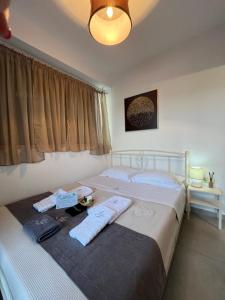 una camera da letto con un grande letto con asciugamani di IONIAN HOSPITALITY ΠΟΛΥΝΟΗ a Lygia