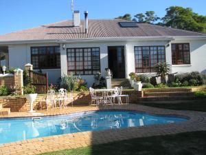 a house with a swimming pool in front of a house at Kaiser's B&B in Grahamstown