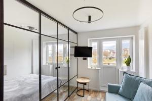 1 dormitorio con 1 cama, 1 silla y ventanas en Kamilkowy Apartament, en Karpacz