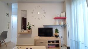 a living room with a tv and a clock on the wall at Rock & Roll 2 - Modern apartment in Trikala in Tríkala