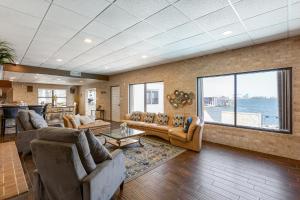 a living room with couches and a view of the water at Bay Dreamer - Massive Bayfront Home with Private Pool home in Galveston