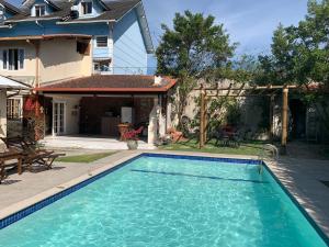 a swimming pool in front of a house at Cantinho na Serra in Teresópolis