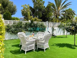 een groep stoelen en een tafel in een tuin bij VALENTINA villa de lujo in Calpe