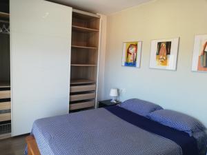 1 dormitorio con cama azul y armario en Panoramic 4 Apartments 1A, en Castelldefels