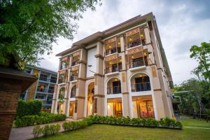 Un grand bâtiment blanc avec de nombreuses fenêtres dans l'établissement Siri Nakornpink Chiang Mai Hotel SHA Plus, à Chiang Mai