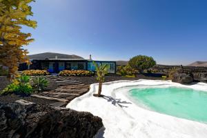 a swimming pool in front of a house at Luxe EcoVilla Listán in Uga