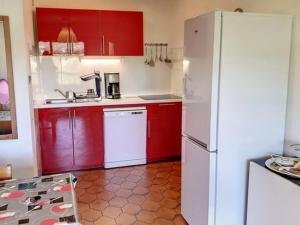 uma cozinha com armários vermelhos e um frigorífico branco em Appartement Bormes-les-Mimosas, 2 pièces, 4 personnes - FR-1-610-16 em Bormes-les-Mimosas