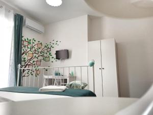 a bedroom with a crib and a table in a room at Hello World in Agrigento