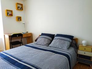 - une chambre dotée d'un lit avec des draps bleus et blancs dans l'établissement Place d'Arradon, à Arradon