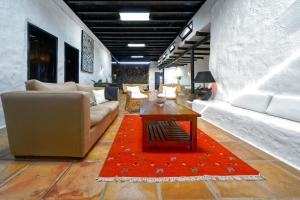 ein Wohnzimmer mit einem Sofa und einem roten Teppich in der Unterkunft Luxe EcoVilla Listán in Uga