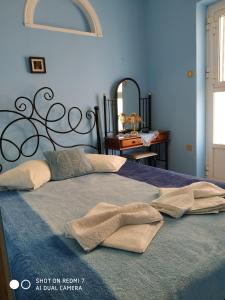 a blue bedroom with a bed with two towels on it at HERMOUPOLI ROOMS in Ermoupoli