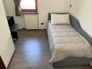 a bed in a small room with a desk at Relax in Valle D'Aosta da B&G in Aosta