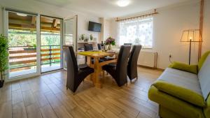 a living room with a table and chairs and a couch at Holiday Home "Sleme" with jacuzzi, big garden and arbor with fireplace in Skrad