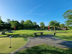 a park with a bench and a golf course at Ferienhaus Nordseekrabbe in Norden