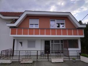 a house with a balcony with a dog in the window at Venera apartman in Ploča