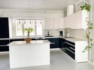 a kitchen with white cabinets and a white island at Maalaistalo maatilamiljöössä in Haapavesi