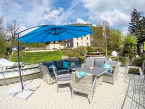 a patio with a table and a blue umbrella at Hausboot Schleuseninsel in Lahnstein