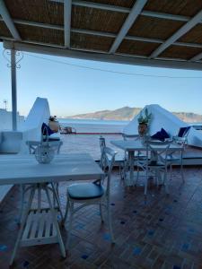 una fila de mesas y sillas con vistas al océano en ANTICA DIMORA Santa Marina Salina en Santa Marina Salina