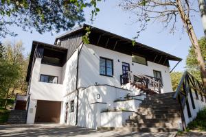 an exterior view of a white house with stairs at Dvi Nidos in Nida