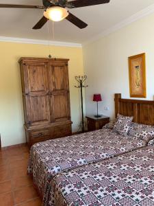 a bedroom with a bed and a ceiling fan at HACIENDA LA HUERTEZUELA y CASA DEL LAGO in Villafranca de Córdoba +61 photos