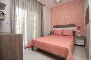 1 dormitorio con cama rosa y ventana en ENIO AXD guest house with private parking, en Alexandroupoli