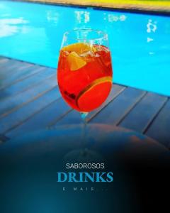 uma bebida num copo ao lado de uma piscina em Atins Charme Chalés em Atins