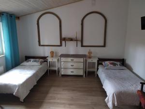 two beds in a room with two mirrors and a dresser at Agroturystyka Klimaty- apartamenty nad rzeką in Międzylesie