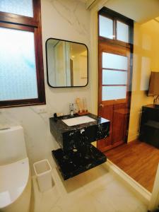 a bathroom with a black sink and a mirror at 海灣旅宿 in Sanzhi